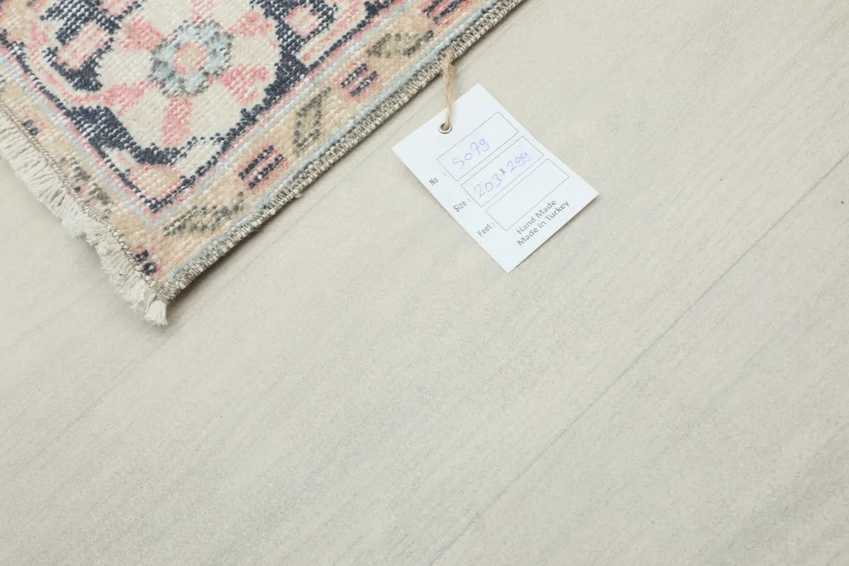 Rug tag displaying origin and material information, next to a small rug section