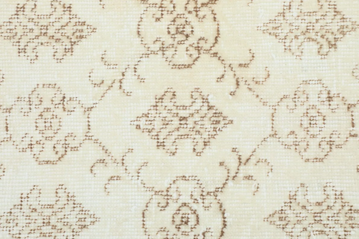 Detailed shot of the hand-knotted wool pile, highlighting the texture and subtle tan motifs.