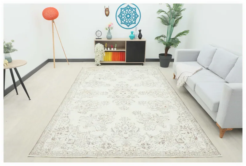 Full top view of the 6'9" x 10'5" ivory beige floral vintage area rug on a white background.