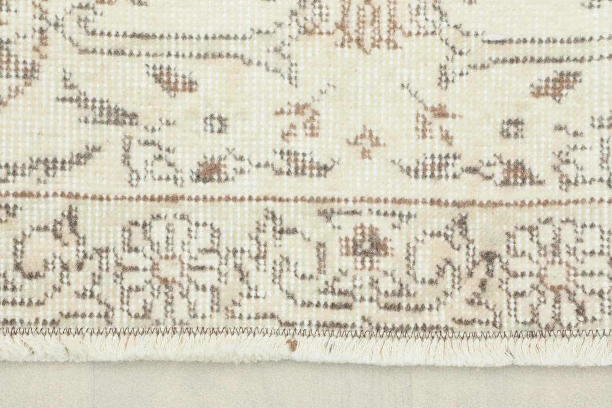 Close-up view of the rug's border and fringe, showing the hand-knotted texture.