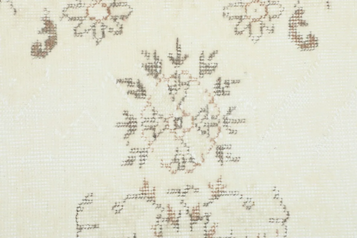 Close-up of a floral motif, highlighting the subtle color variations and low pile.