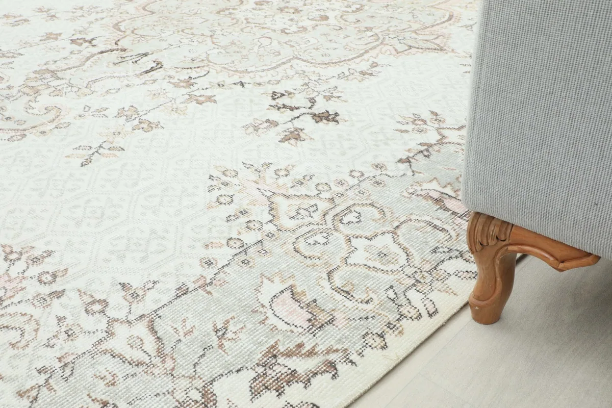 Close-up of the rug's edge under a sofa leg, showing its integration into a room