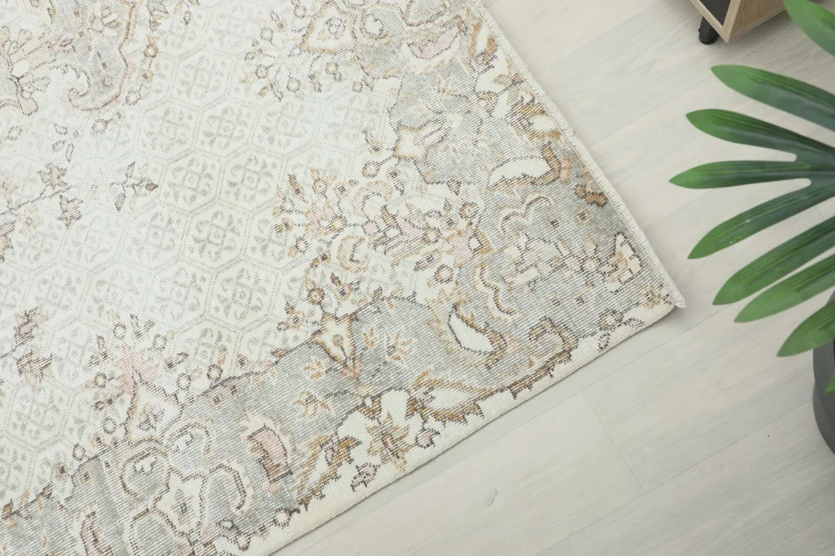 Corner view highlighting the rug's border design and overall muted color palette