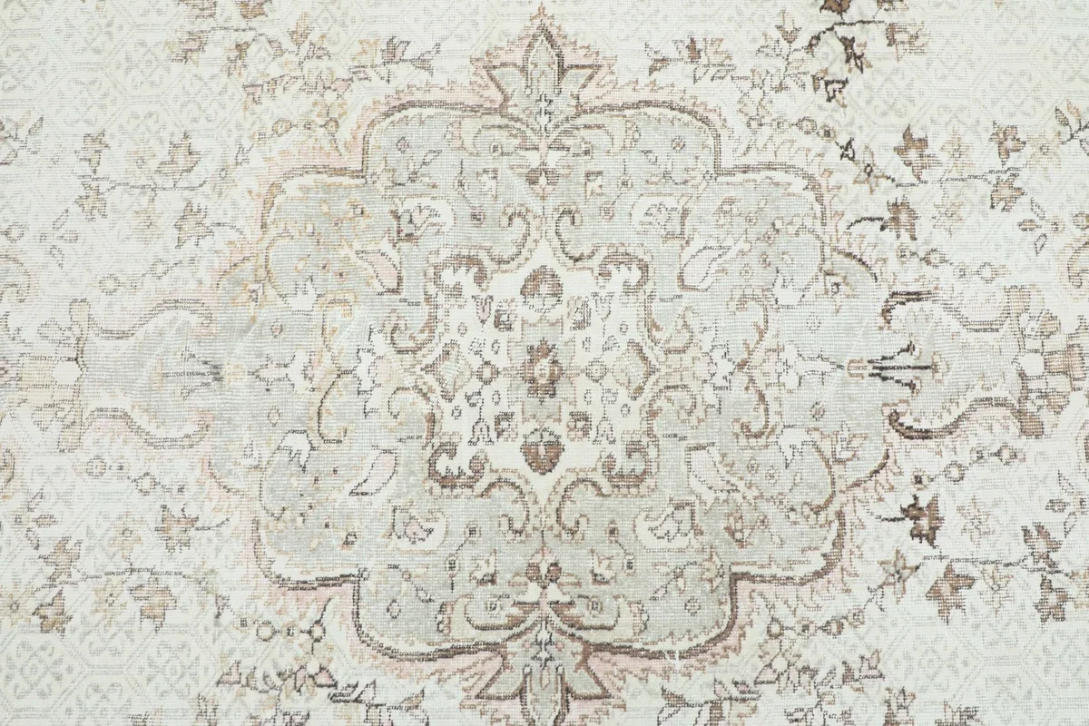 Overhead view of the central medallion and surrounding floral patterns on the vintage rug