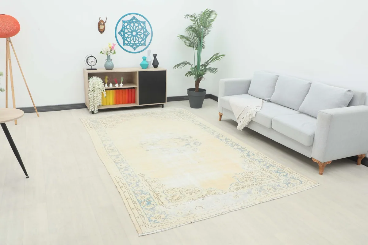 Large ivory and blue vintage area rug displayed in a modern living room setting