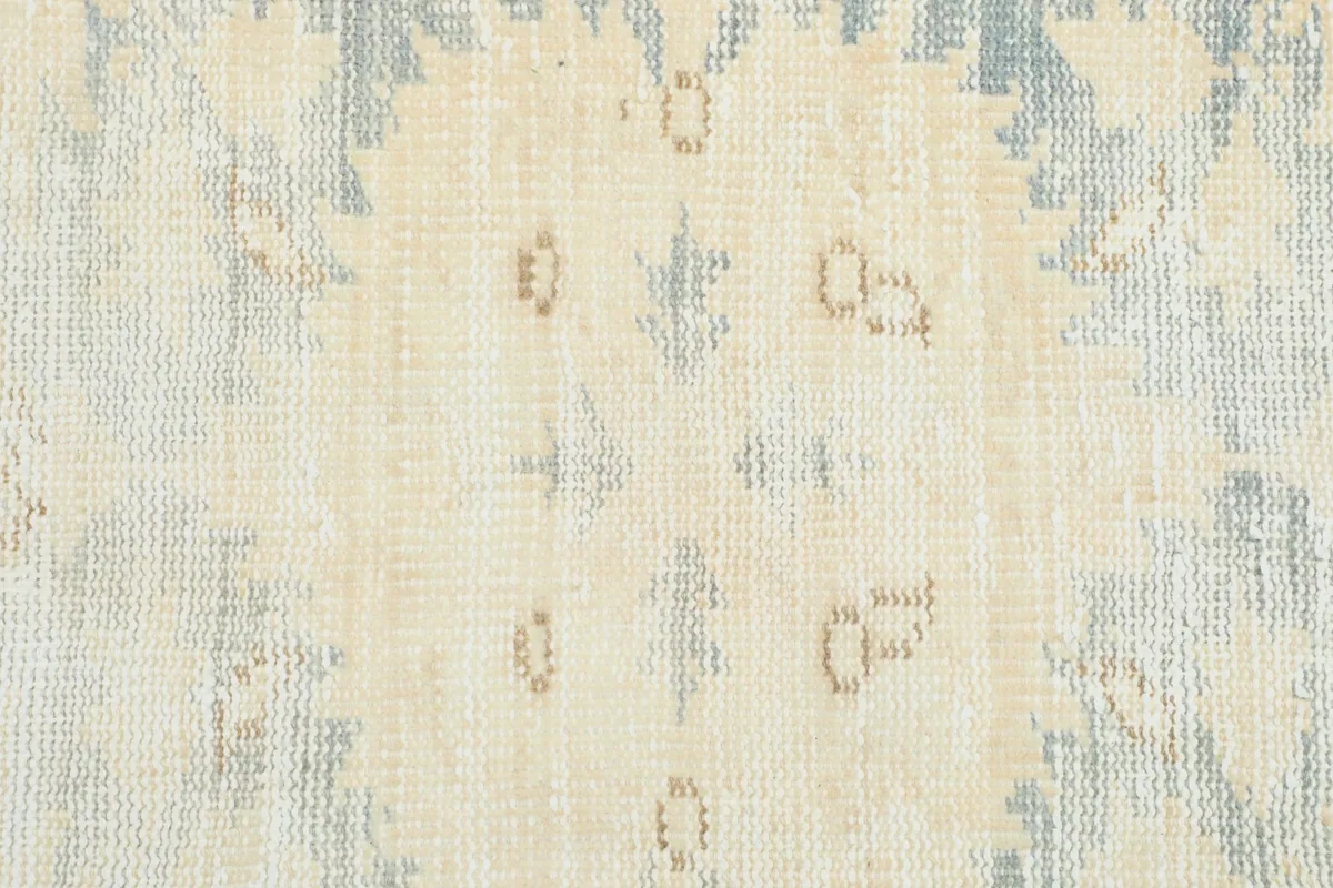 Close-up of the distressed texture and subtle beige accents within the rug's pattern