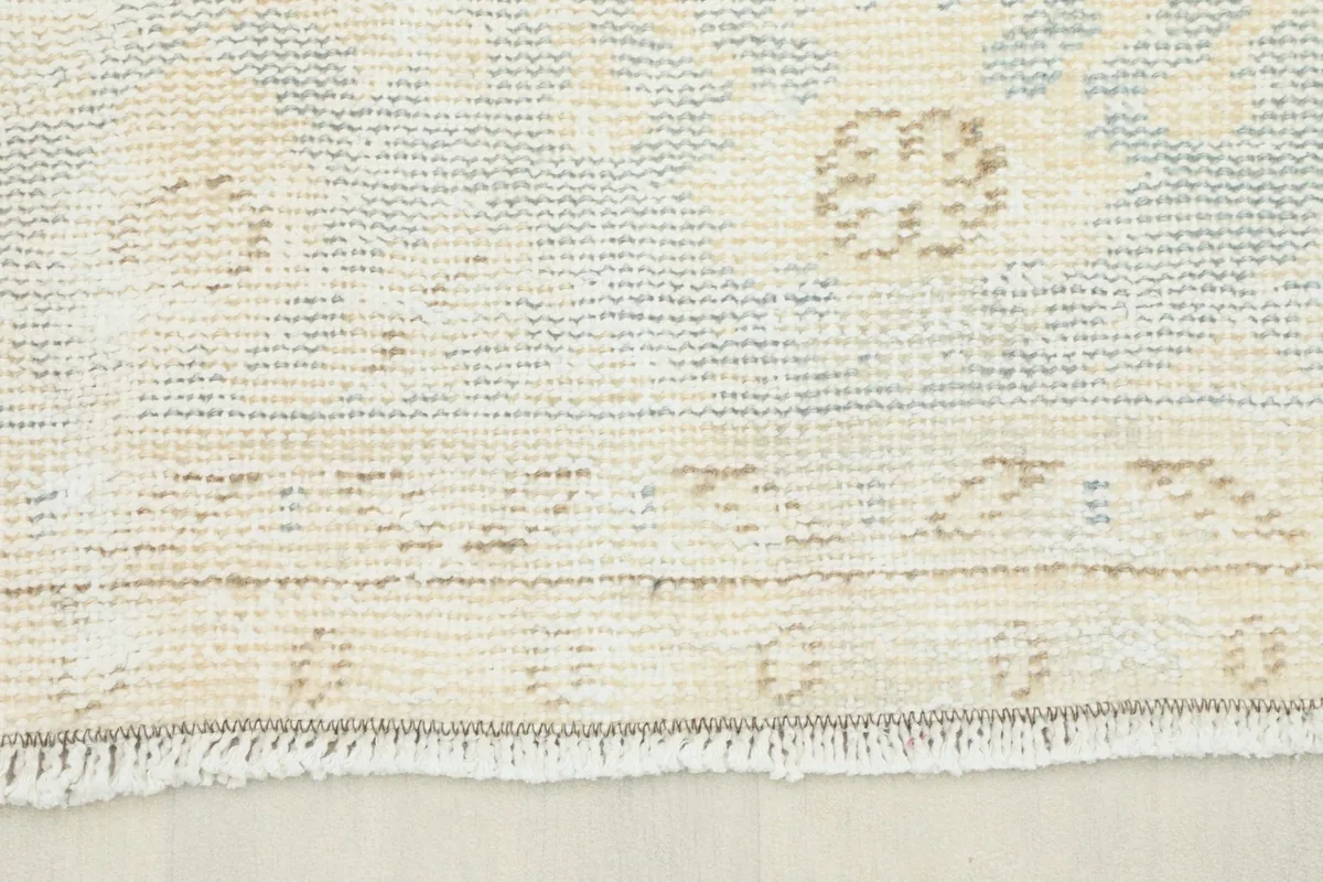 Close-up of the short fringe and edge of the vintage hand-knotted wool rug