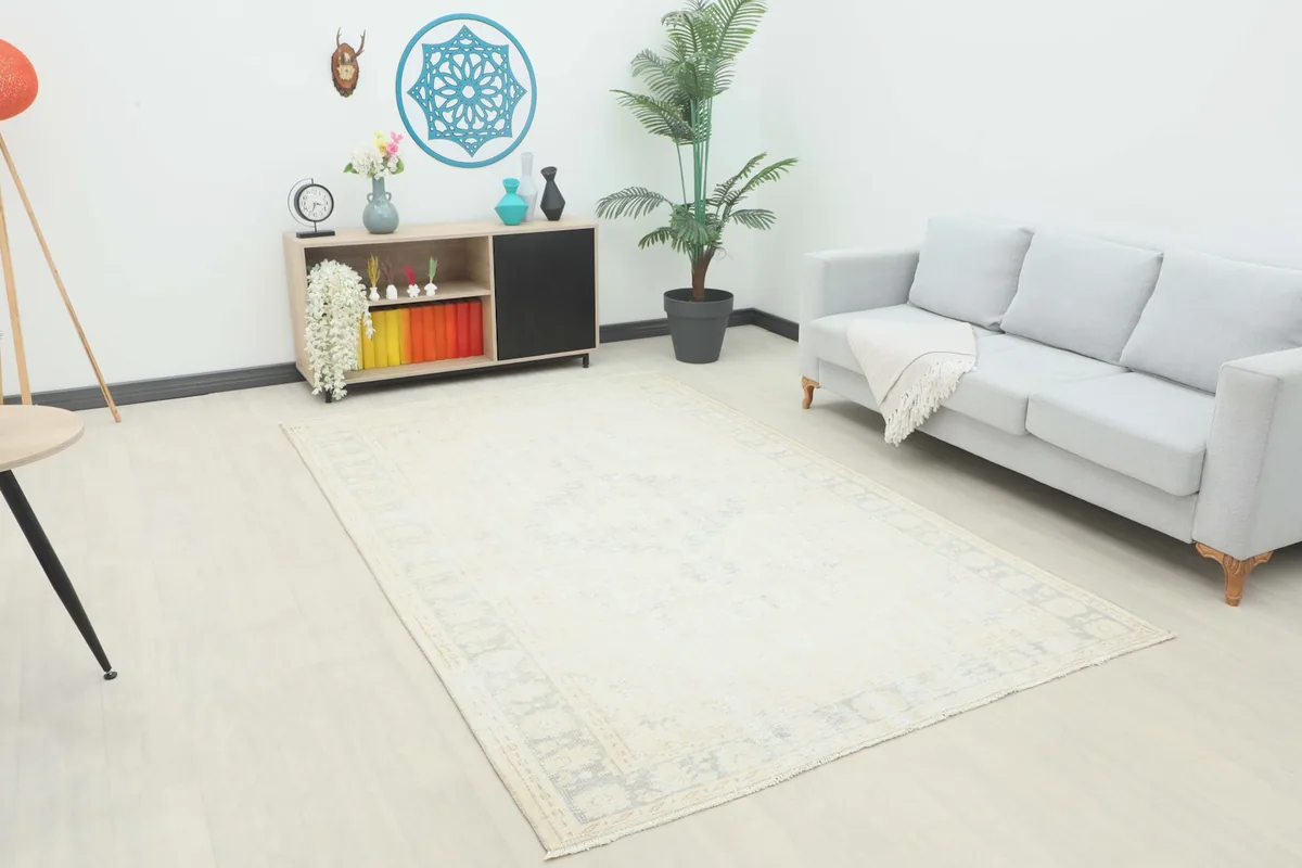 Vintage ivory and gray rug displayed in a bright living room setting with a sofa