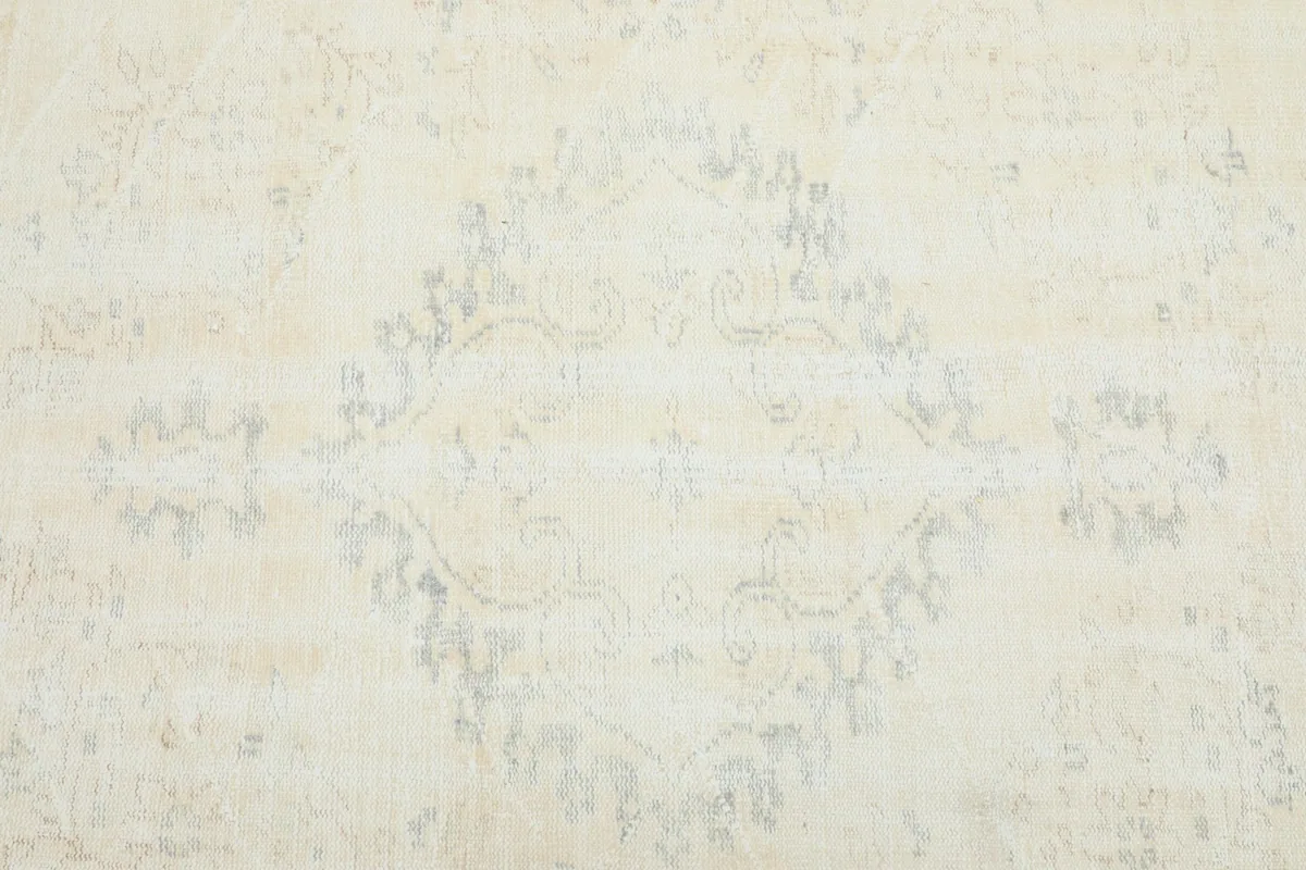 Detailed view of the central faded medallion motif in ivory and light gray