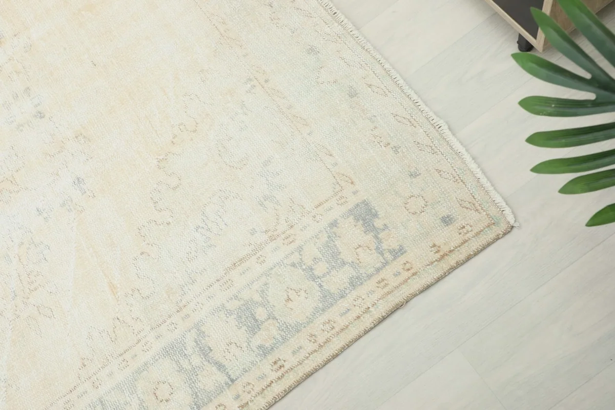 Corner detail of the rug, highlighting the geometric border pattern in gray and ivory