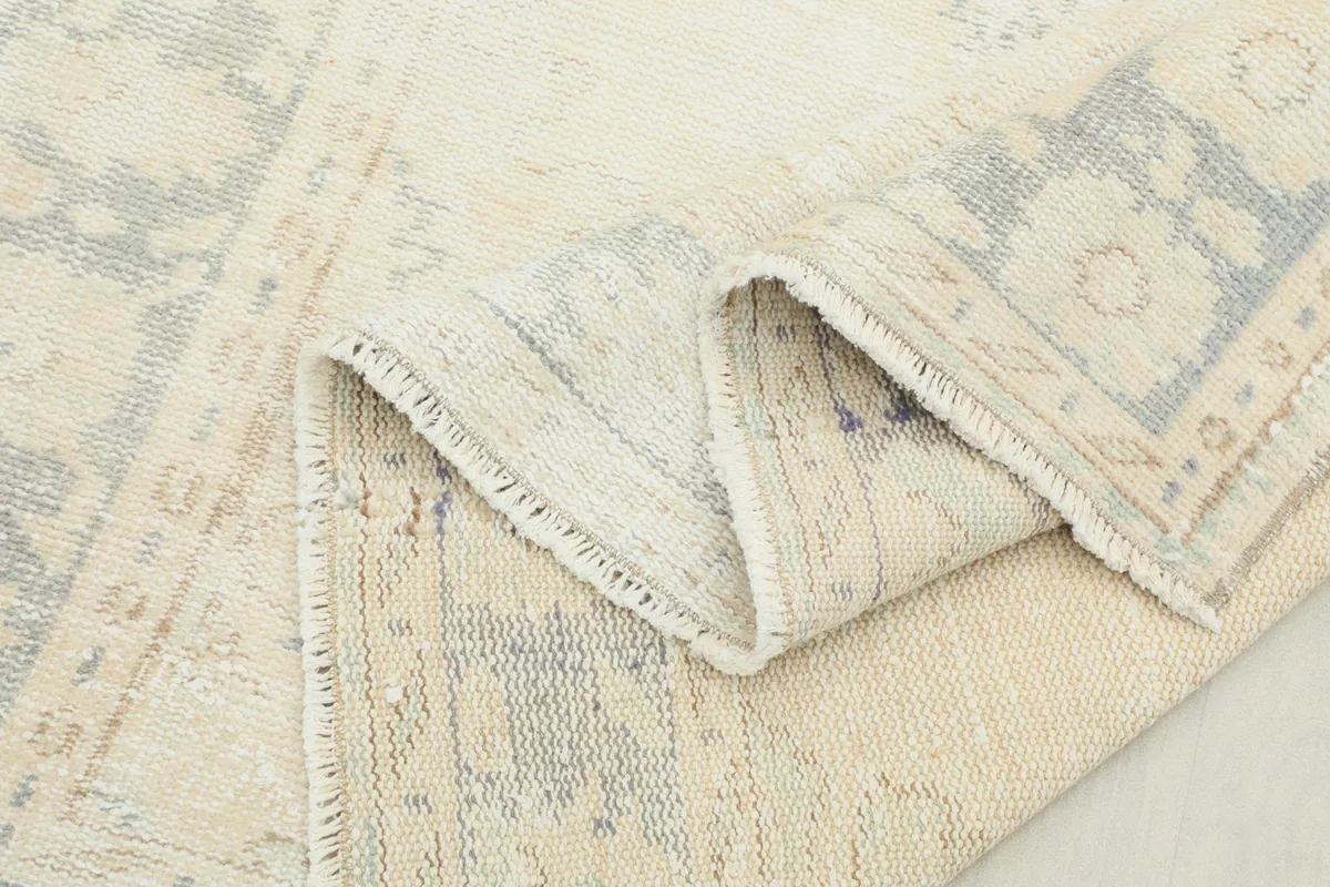 Another view of the folded rug, showing the reverse side and knotting detail