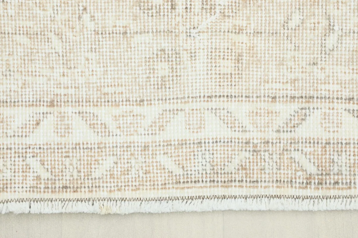 Close-up view of the rug's border and fringe, showing the hand-knotted texture