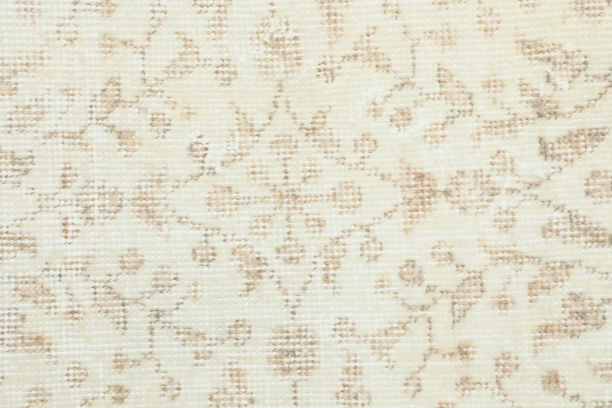 Close-up of the low wool pile, showing the intricate beige and tan motifs