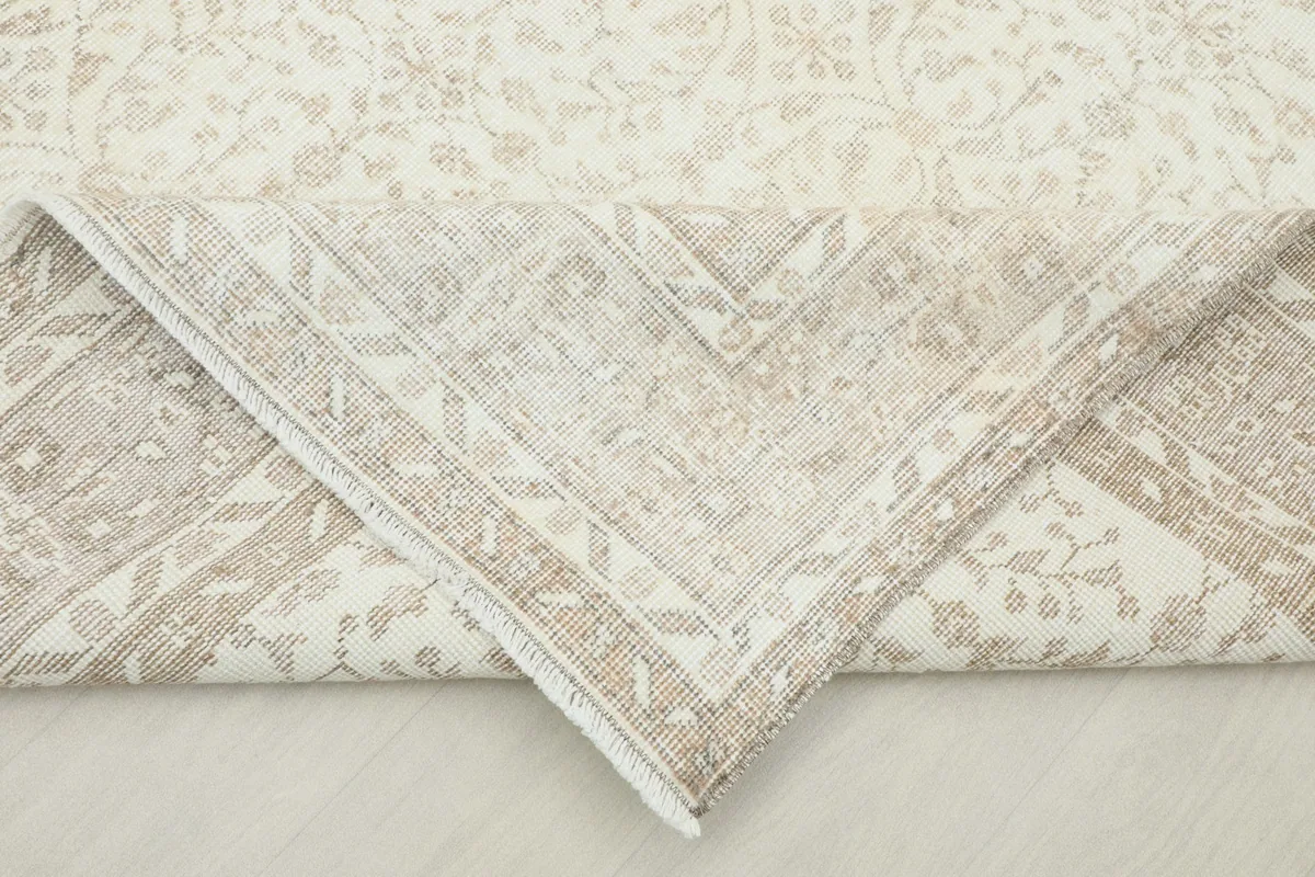 View of the rug's underside and folded corner, revealing its cotton foundation