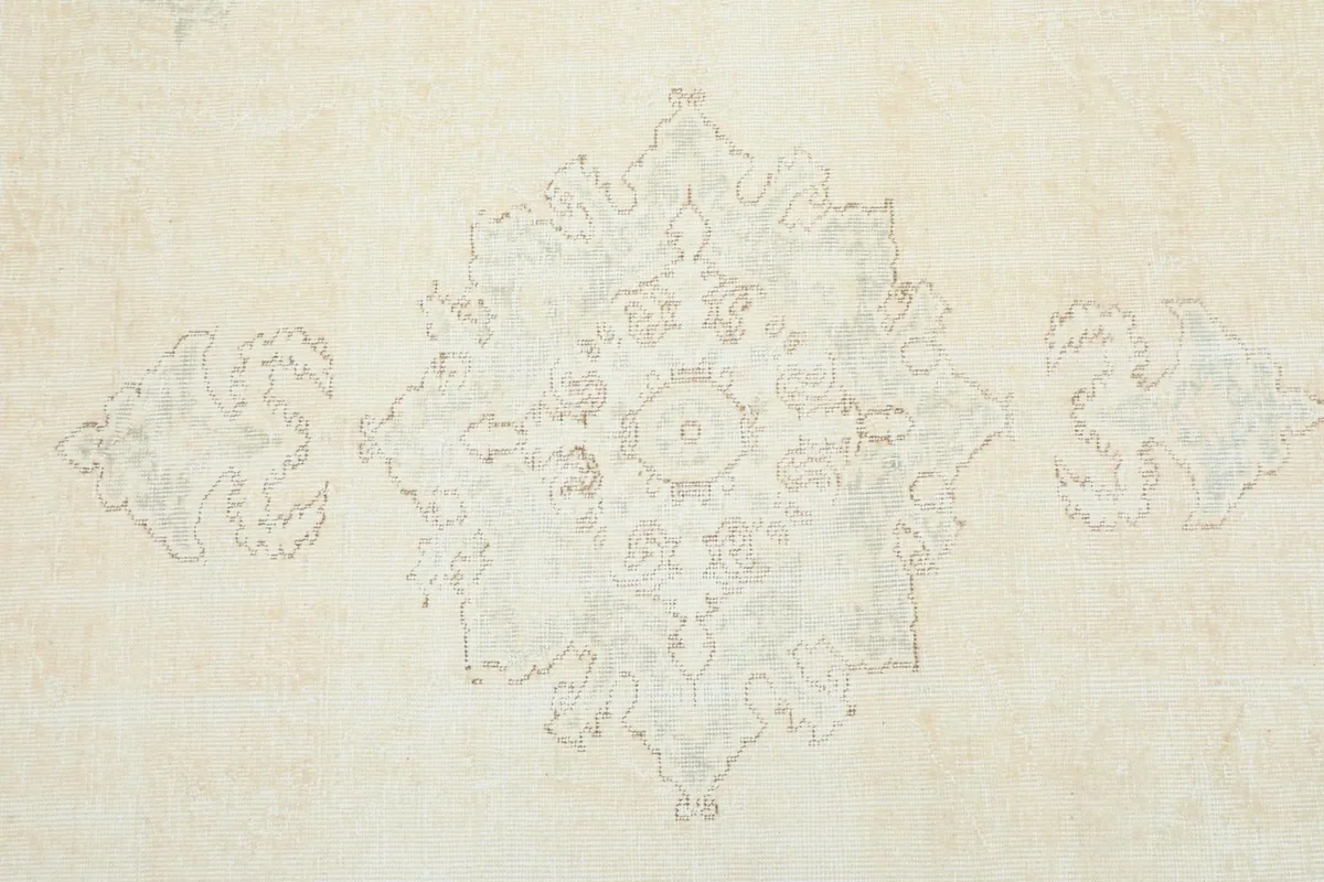 Close-up of the central medallion pattern in subtle ivory and beige tones