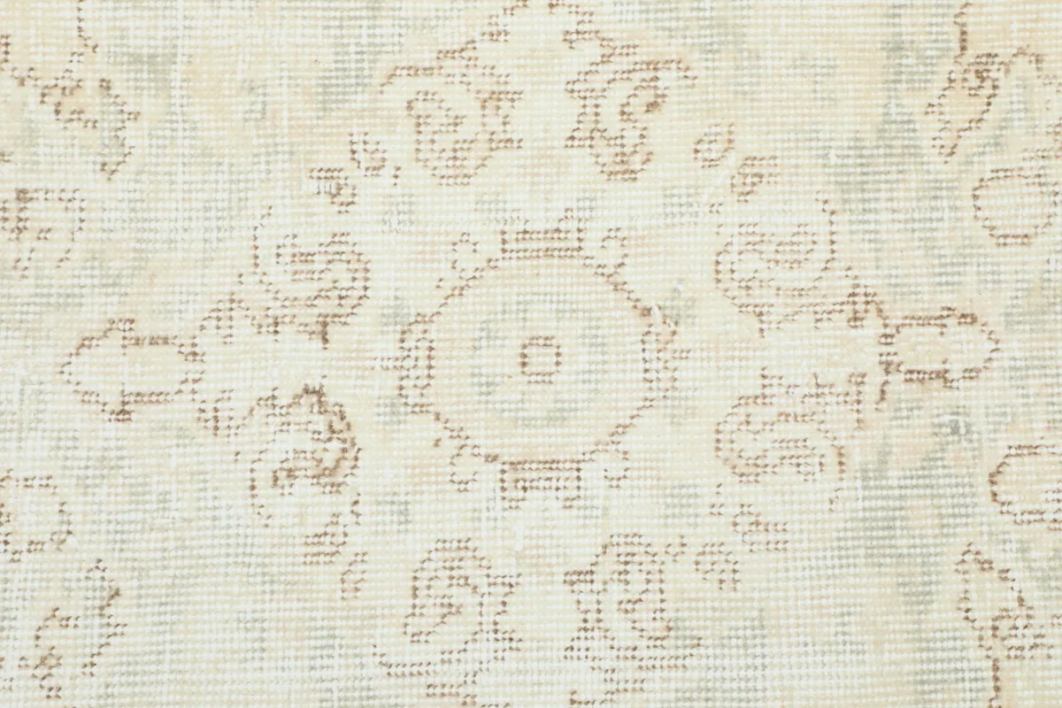 Detailed view of the vintage wool pile and faded floral motifs