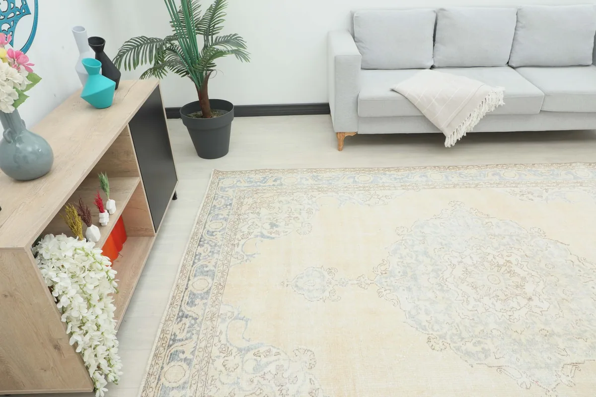 Angle view of the rug in a room, showing its scale next to a sofa and cabinet