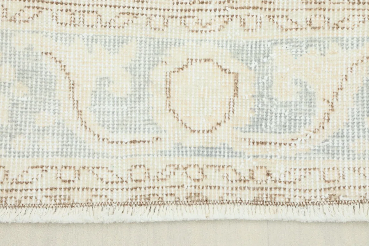 Close-up view of the rug's border pattern and fringe detail