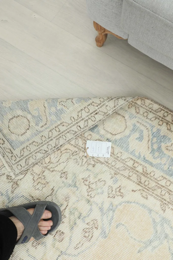Foot on the rug, showing the low pile and texture of the vintage wool