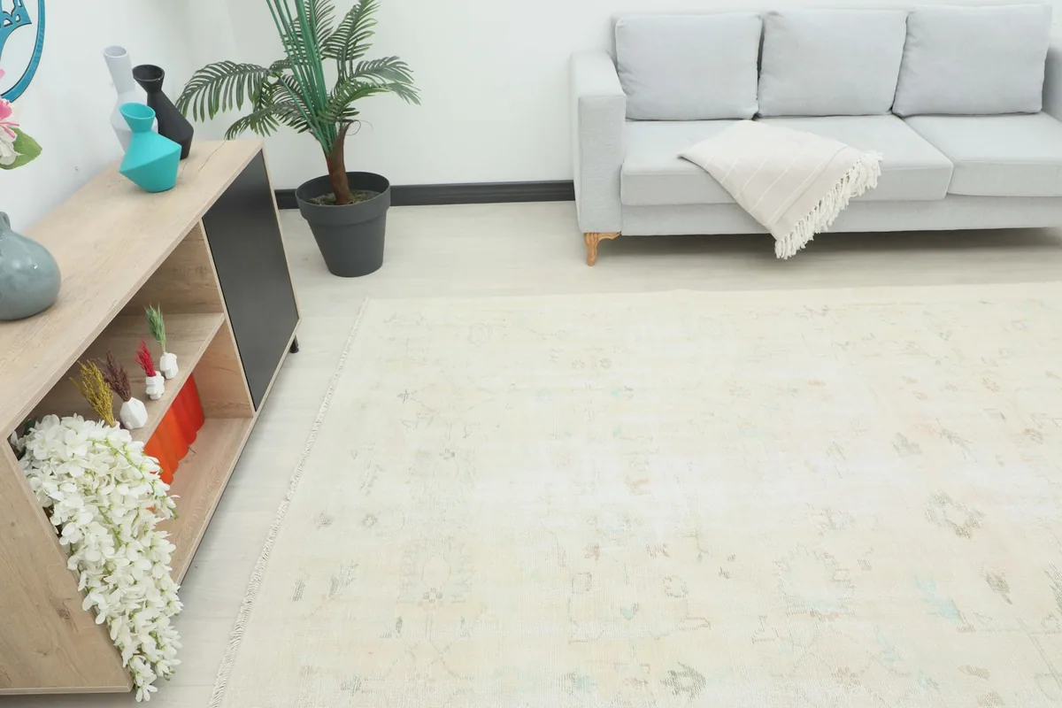 Angle view of the ivory rug in a living space, showing its large size relative to furniture