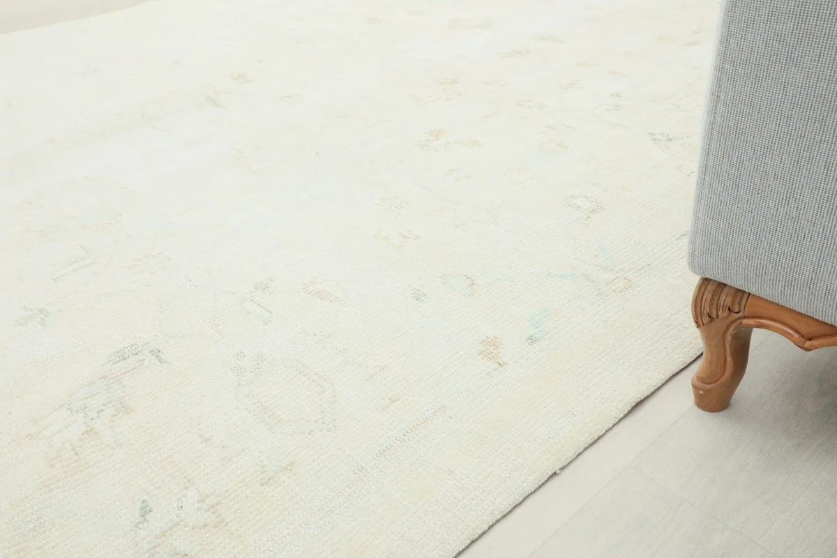 View of the rug extending under a sofa, highlighting its large size and placement in a room