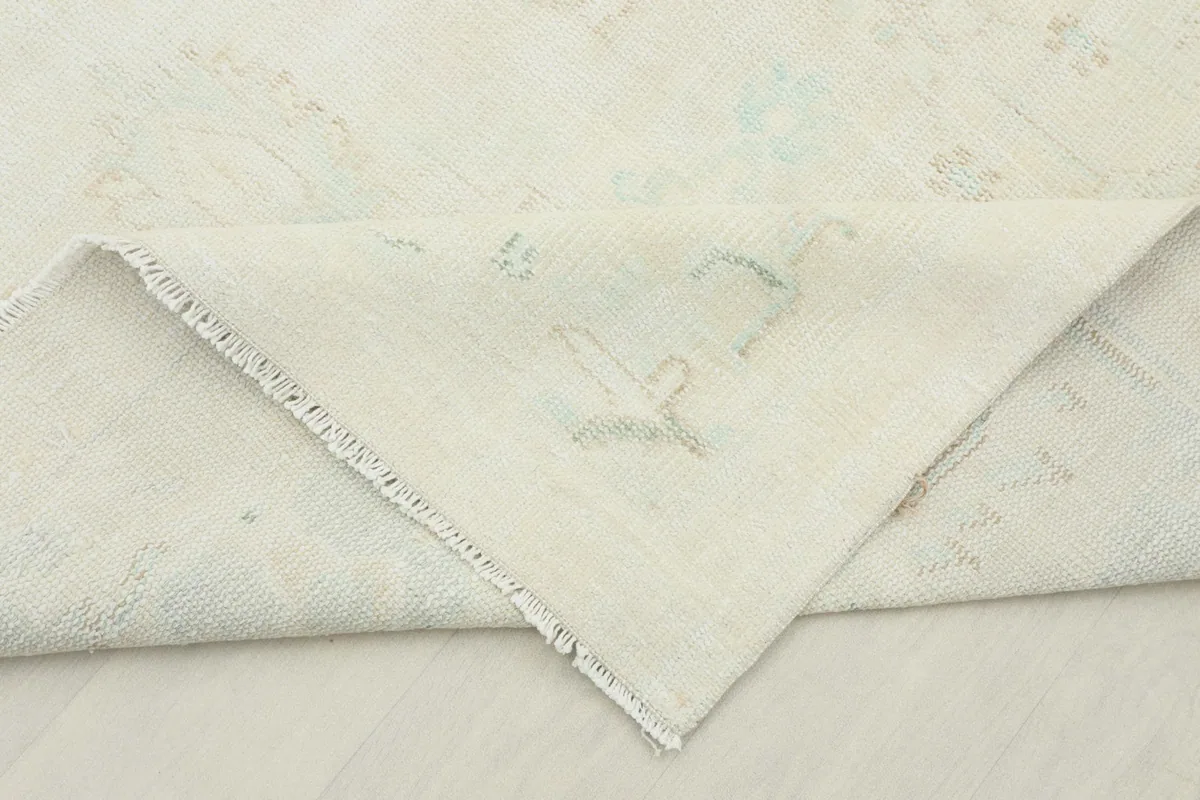 Folded corner of the rug revealing the cotton foundation and hand-knotted construction