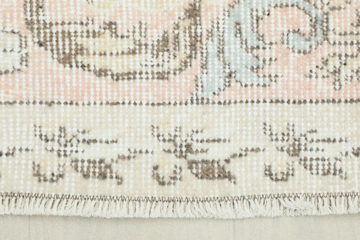 Close-up view of the rug's short fringe and a section of the border pattern