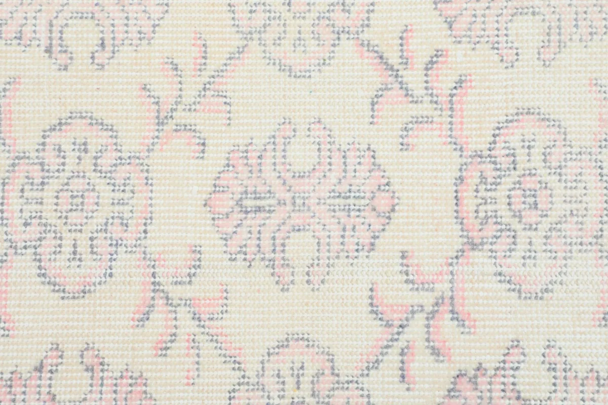 Detailed view highlighting the hand-knotted texture and delicate rose and gray motifs.
