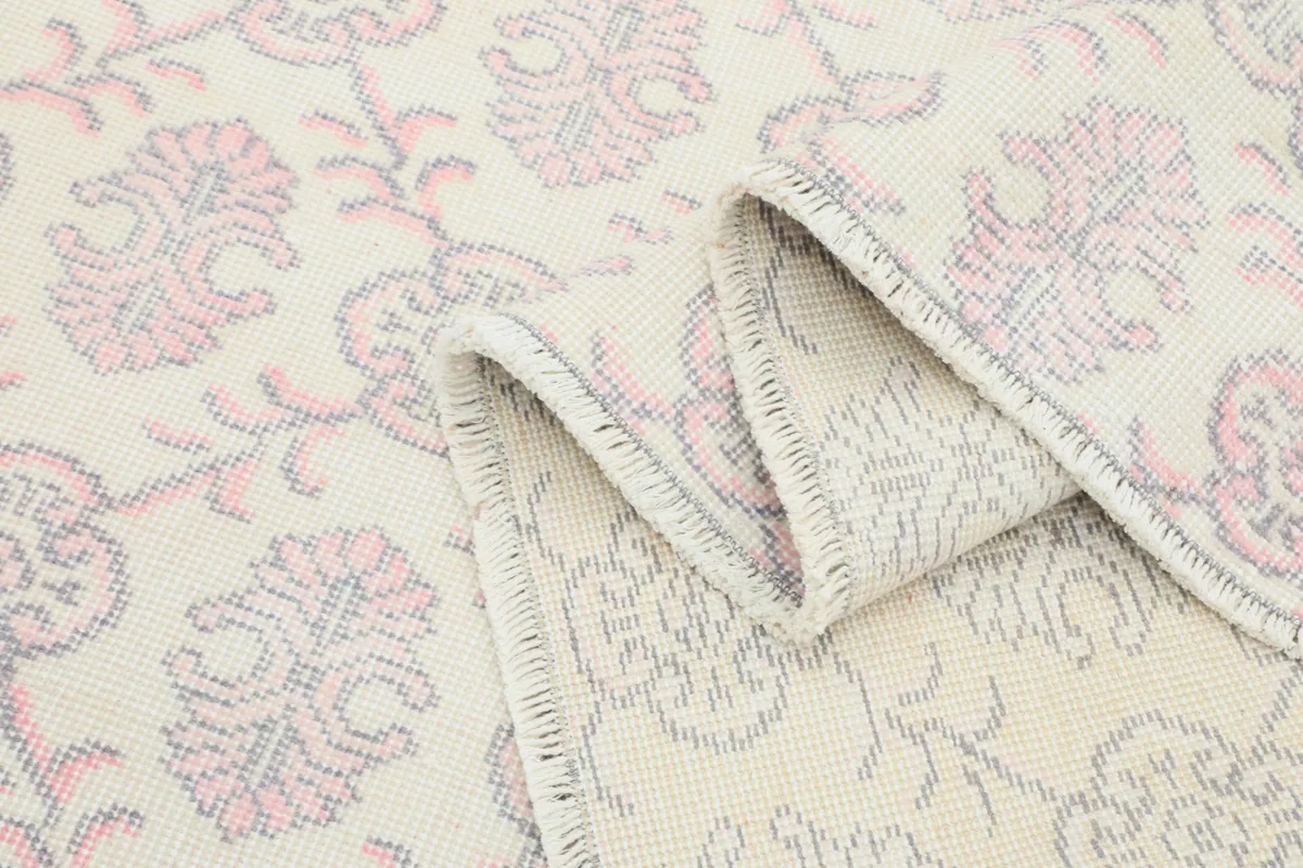Close-up of the rug's low pile and the intricate knotting visible in a folded section.