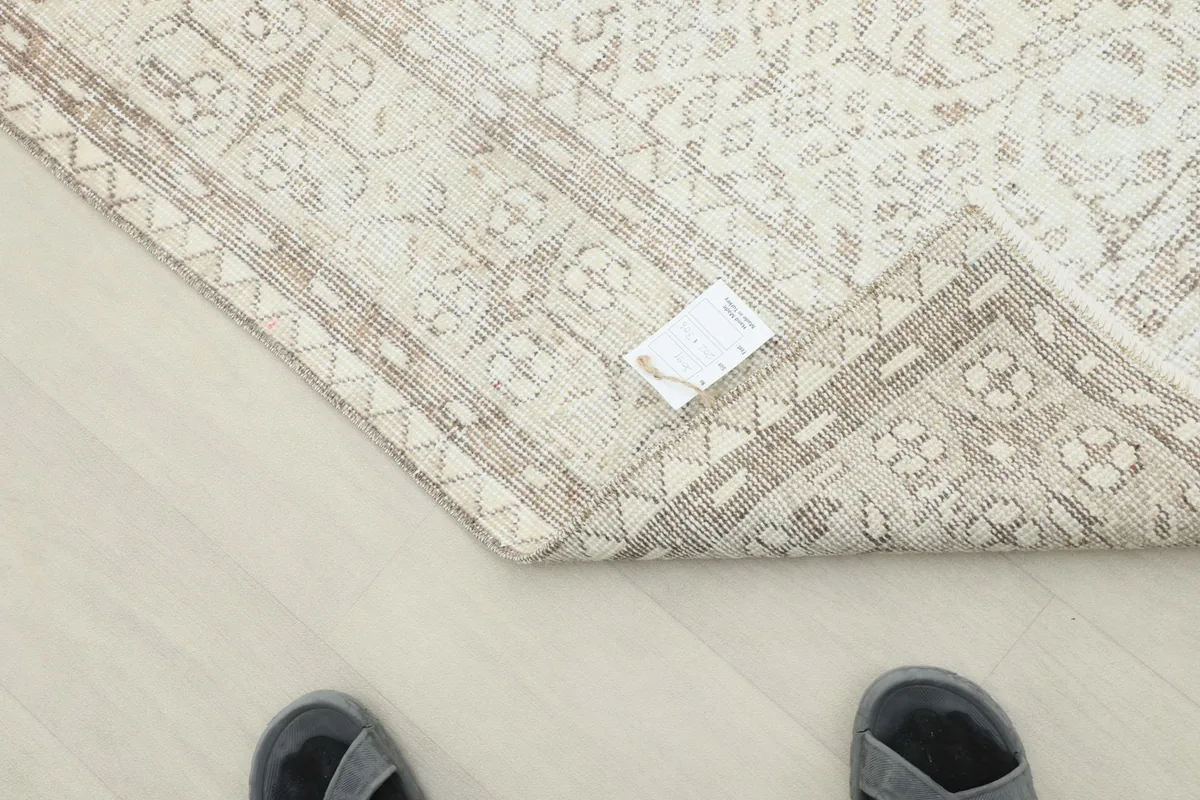 Underside and corner of the rug, displaying the hand-knotted construction and fringe