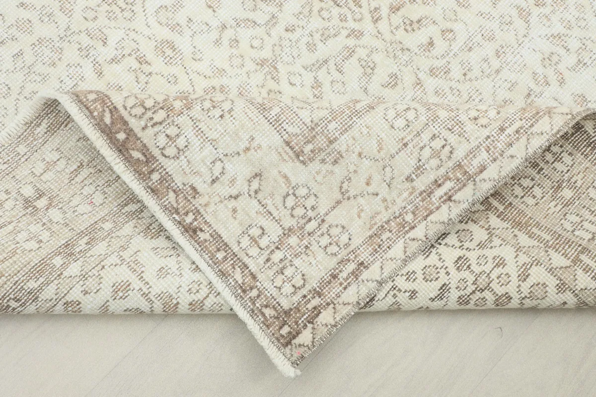 Corner of the rug folded to show the wool pile texture and cotton foundation