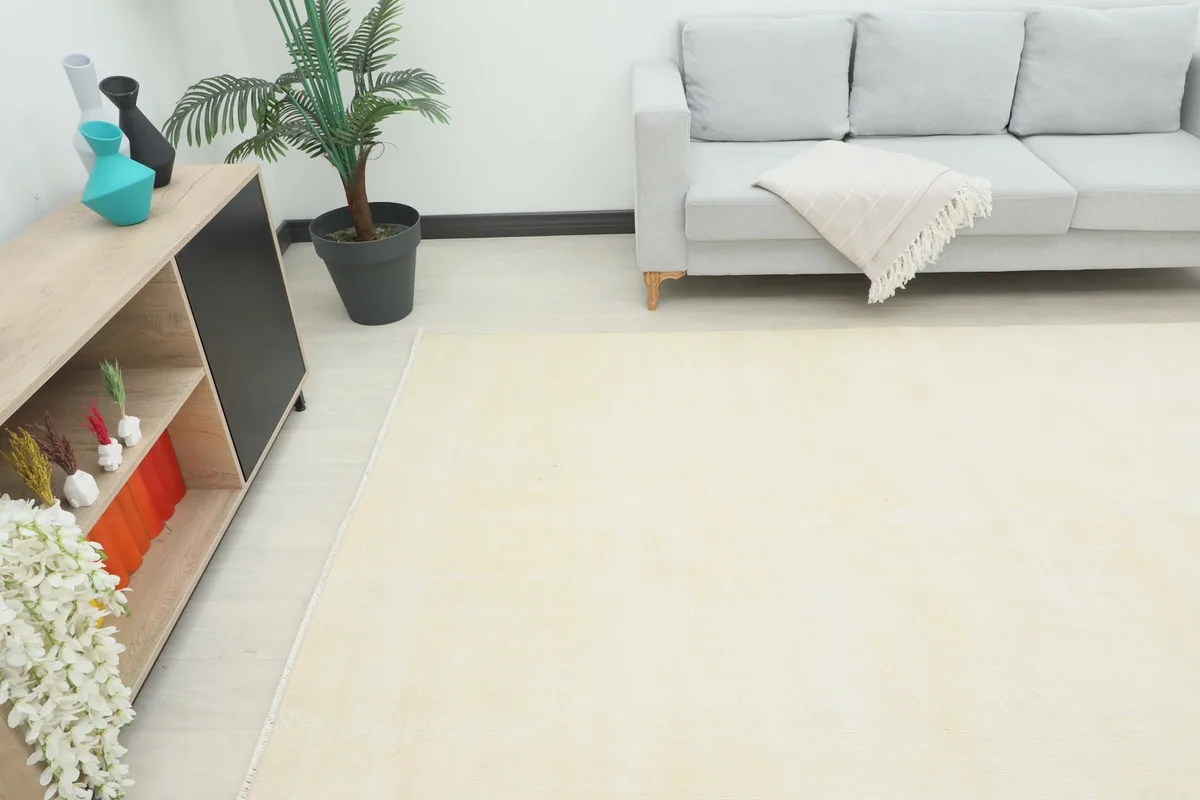 Angle view of the cream rug in a living room, showing its placement relative to furniture