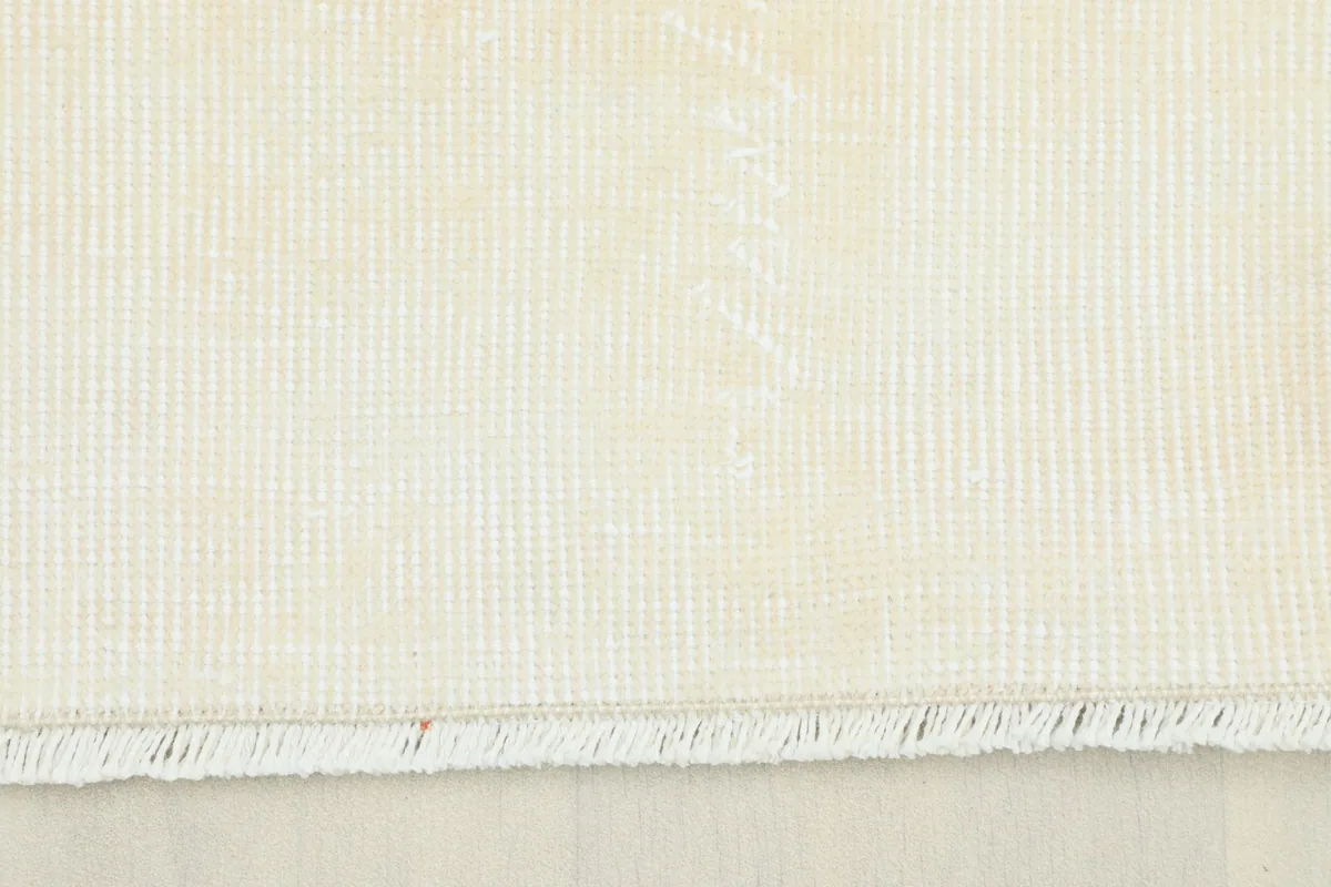Close-up view of the back of the hand-knotted wool rug showing the cotton foundation