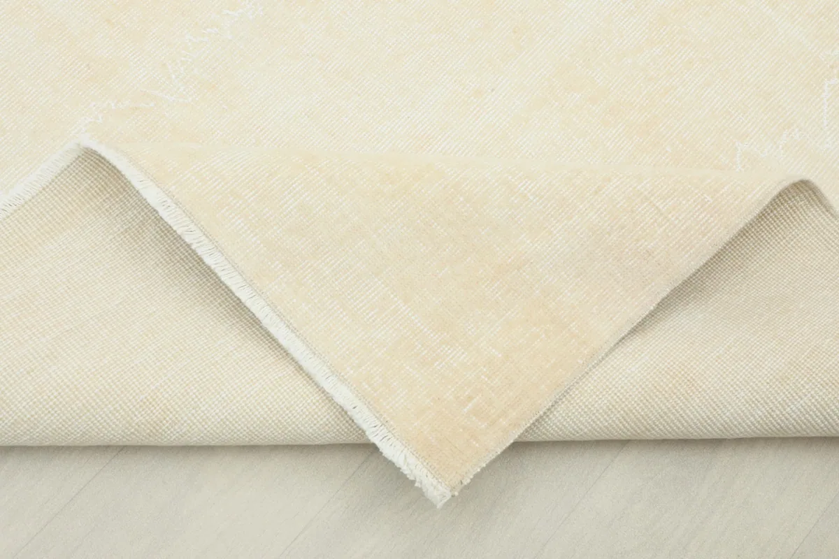 Folded section of the rug revealing the thickness and the back of the hand-knotted construction
