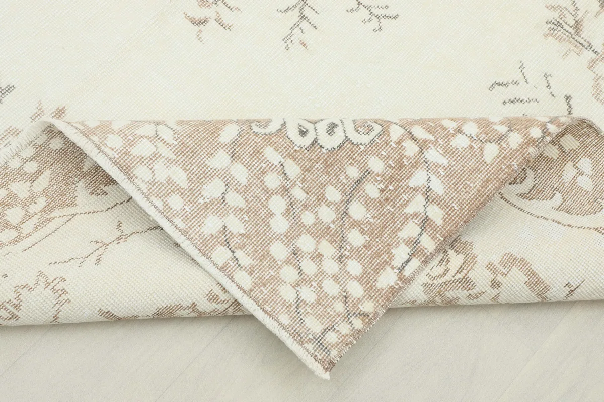 Folded corner showing the rug's wool pile on the front and cotton foundation on the back