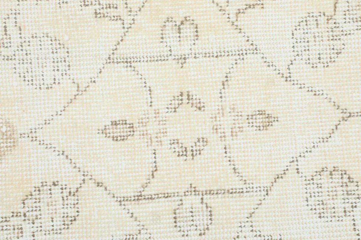 Close-up of the intricate hand-knotted texture and faded motifs within the rug's pattern
