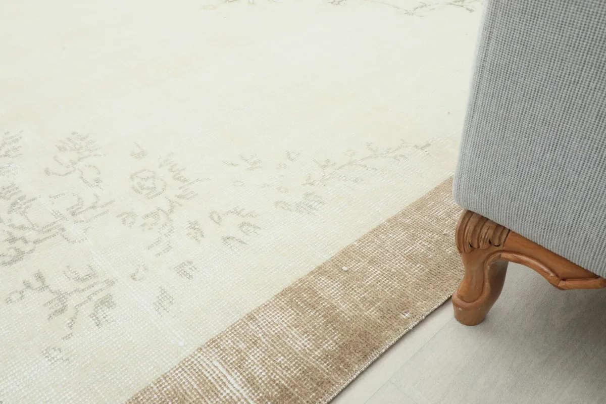 Close-up of the rug's edge next to a furniture leg, demonstrating its low pile.