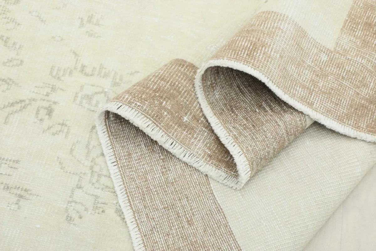 Folded edge of the rug showing the thickness of the wool pile and the construction.