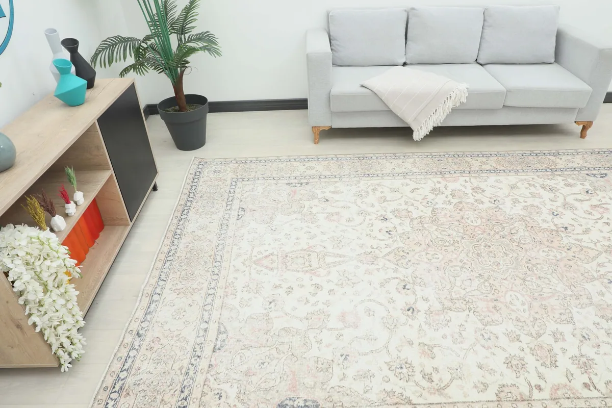 Angle view of the large ivory rug in a room, showing its scale next to furniture