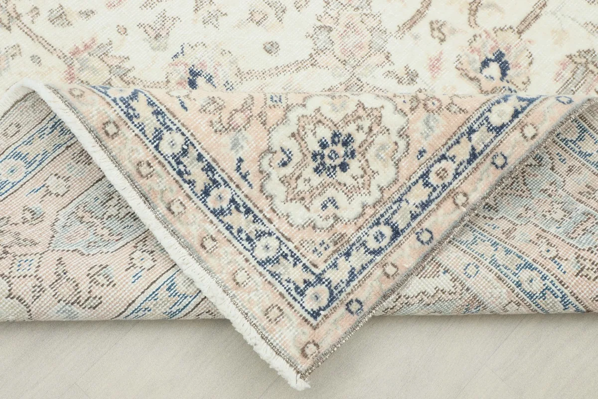 Folded corner of the rug, showing the reverse side and the hand-knotted construction