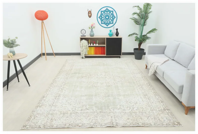 Full top view of the 7'3" x 10'4" faded green and beige vintage Anatolian area rug on a white background.
