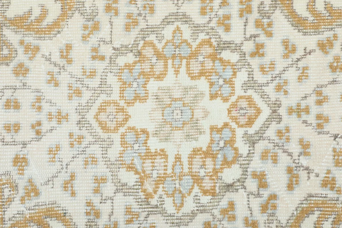 Close-up of the intricate gold, gray, and ivory floral patterns within the central medallion.