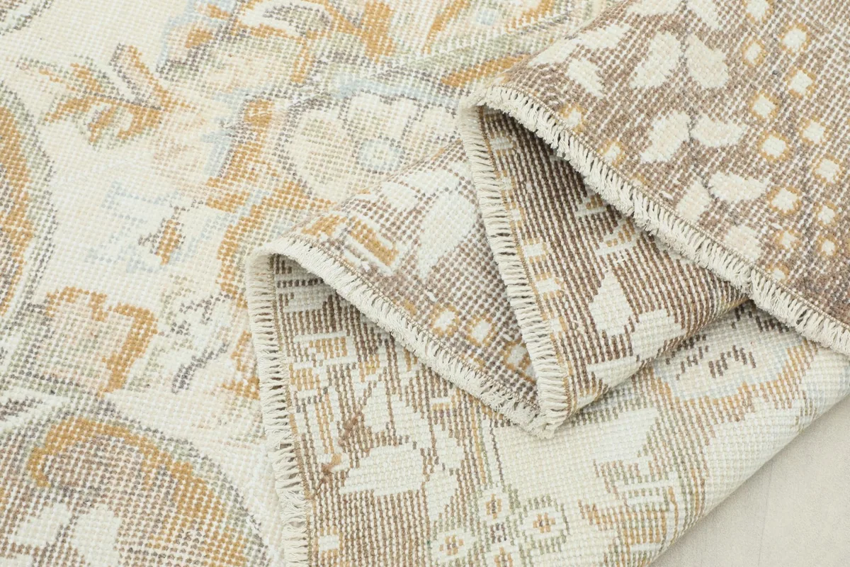Folded section of the rug, revealing the texture of the hand-knotted wool pile and its foundation.