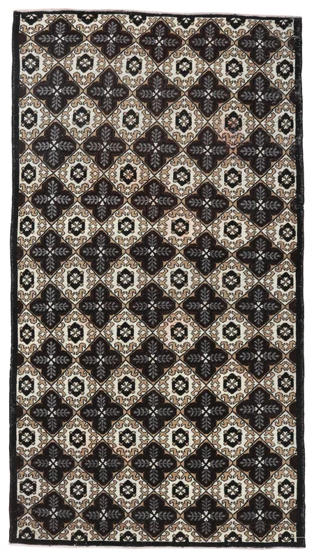 Full overhead view of the black, ivory, tan, and gray geometric Anatolian area rug
