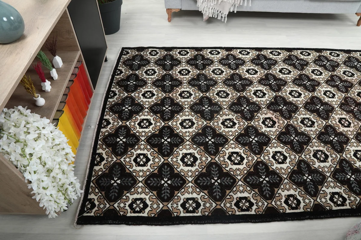 Rug placed in a room, showing its texture and pattern from a side angle