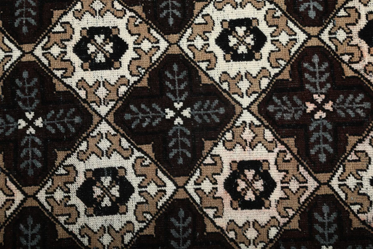 Close-up of the intricate geometric pattern and color variations in the rug pile
