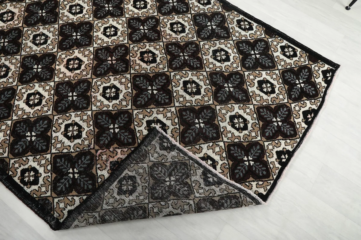 Corner of the rug folded back to reveal the cotton foundation and reverse side