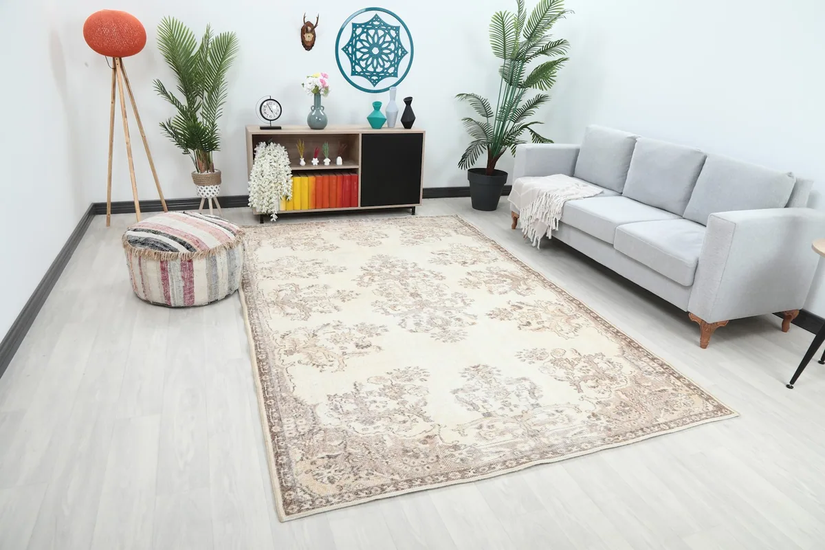 Overhead angle of the large ivory and tan floral rug in a room