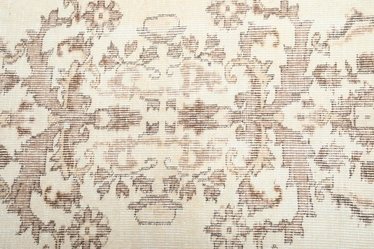 Close-up of the hand-knotted wool pile and faded floral motifs