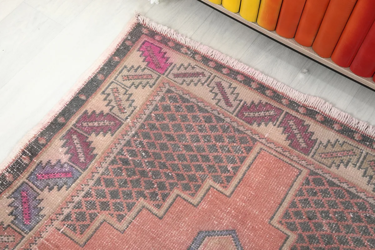 View of the upper right corner of the rug, showing the distinct border design and color variations